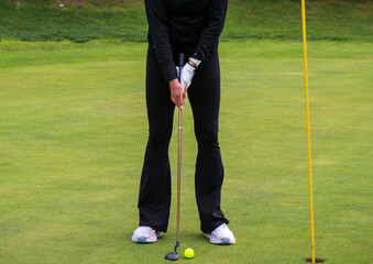 Golfer Prepares to Putt on a Lush Green Golf Course