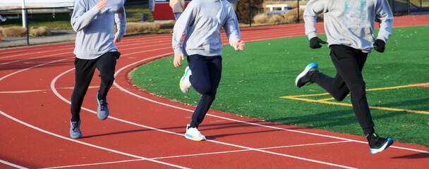 Three Runners Train on Track in Daytime Competition