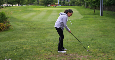 Woman Preparing to Hit Golf Ball off the tee