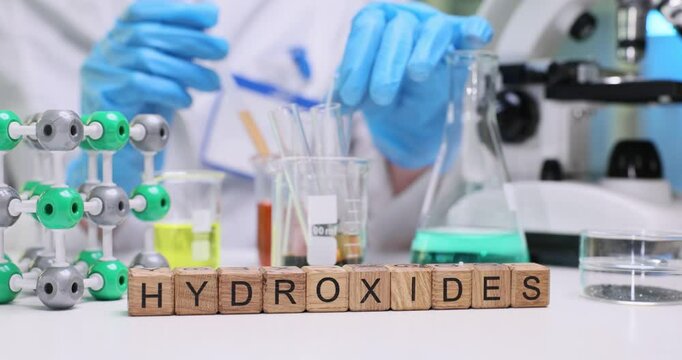 A scientist studies hydroxides using specialized lab equipment and chemicals to enhance understanding