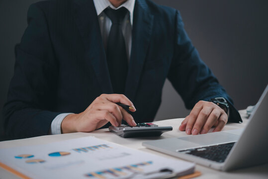 Financial professional using calculator and pen, budget management accounting, business data analysis, and meticulous financial planning for investment and taxation. - Powered by Adobe