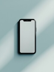Black smartphone on light green surface with shadows and blank screen display