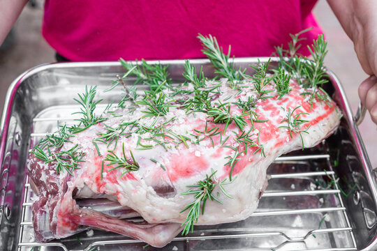 prepared lamb leg ready for roasting, with garlic, rosemary, salt and olive oil