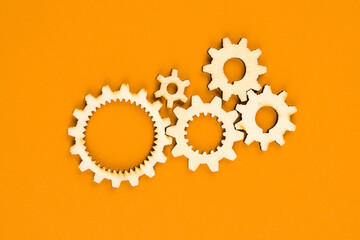 Wooden cogwheels on orange background