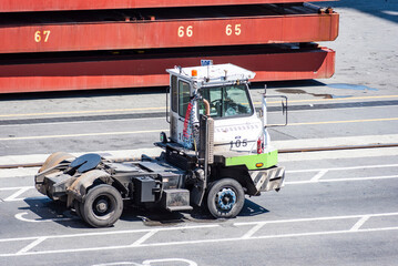Container terminal truck parked near cargo ship - terminal equipment for handling cargo containers.