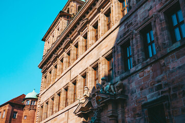 Old architectural building in Nuremberg city against blue bright sky. Cityscape