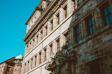 Old architectural building in Nuremberg city against blue bright sky. Cityscape