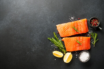Raw salmon fillet with spices. Top view on black background.