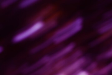 Blurry luminous streaks of violet dance across a darkened backdrop