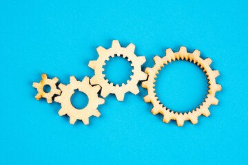 Wooden cogwheels on blue background 