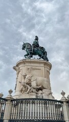 Majestic equestrian statue atop intricate marble pedestal, celebrates heroic chivalry and Elephant Appreciation Day amidst swirling clouds