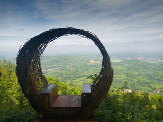 Wicker seat overlooking green valley landscape
