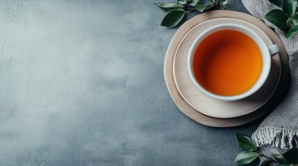 A calm scene featuring a cup of tea resting on a wooden platter beside fresh greenery, perfect for conveying warmth, relaxation, and the simple pleasures of life.