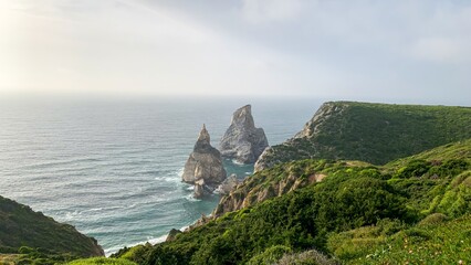 Cliffs embrace the ocean under ethereal skies, whispering tales of Beltane mystique and forgotten maritime legends