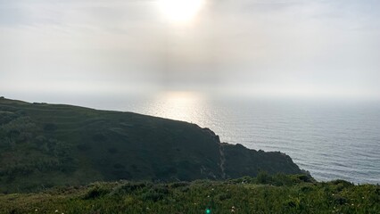 Sunlit whispers kiss misty coastal cliffs, invoking tranquil Celtic mythos and Lughnasadh Festival, where nature's serenity reigns