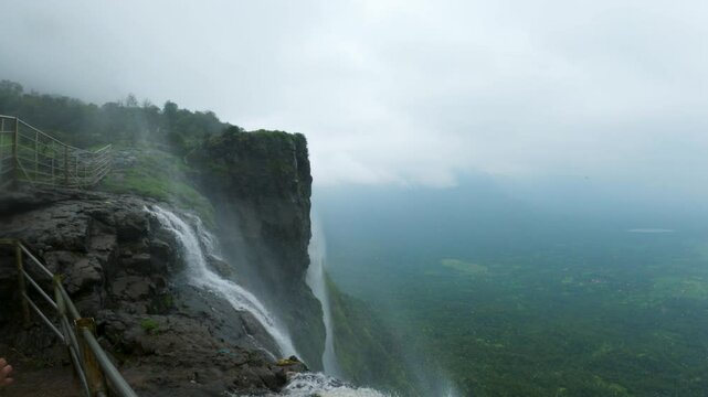 4K shot of reverse waterfall at Naneghat in Maharashtra, India during the monsoon season. Waterfall flows in reverse due to the strong winds in Sahyadri hills. Natural background with copy space.