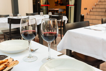 Two glasses of red wine on a table in an outdoor cafe. summer day.