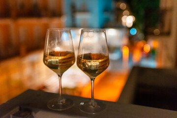 Two glasses of wine on the balcony ledge of a hotel in the summer evening, at night. Vacation time.