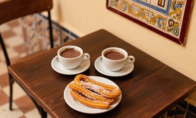 Golden churros and rich hot chocolate photographed in warm European morning light