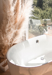 royal freestanding huge white bathtub in boho style bathroom near window in morning lights, free space
