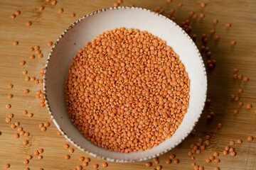 Dry red lentils spread on a plate. 