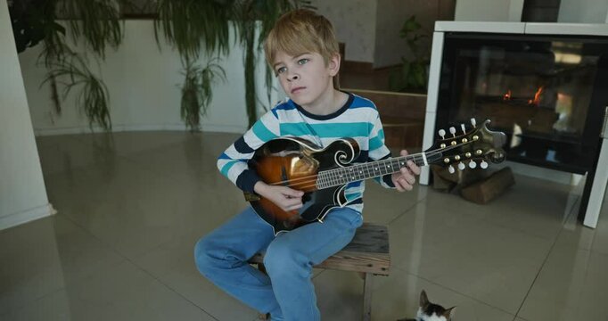 Caucasian Kid Play Mandolin at Home. European Boy Practice Music 4K 10-bit