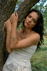 Curly haired woman in a white dress enjoying a summer day amidst nature