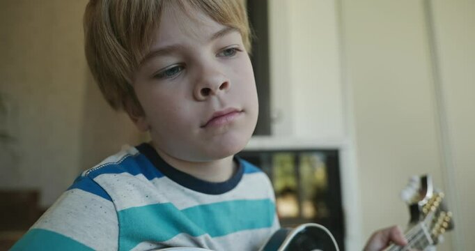 Caucasian Kid Play Mandolin at Home. European Boy Practice Music 4K 10-bit