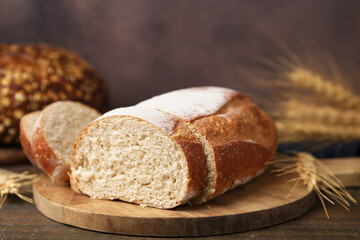 Fresh cut bread and spikes on wooden table, closeup