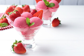 Refreshing sorbet, strawberries and mint in dessert bowls on white wooden table, closeup