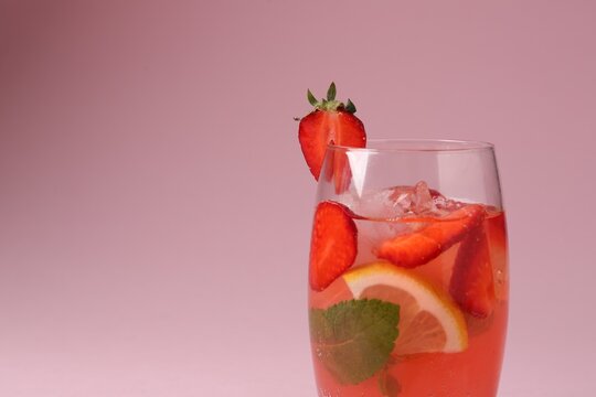 Refreshing drink with strawberries, mint, lemon and ice in glass on pink background, closeup. Space for text - Powered by Adobe