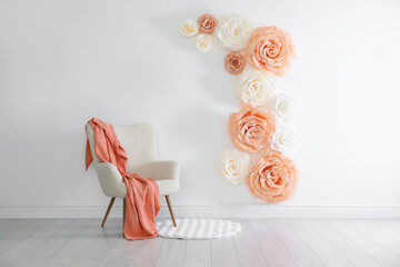 Photo zone with beautiful floral decor and armchair in studio