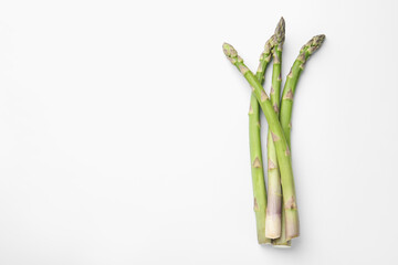 Fresh ripe raw asparagus on white background, top view. Space for text