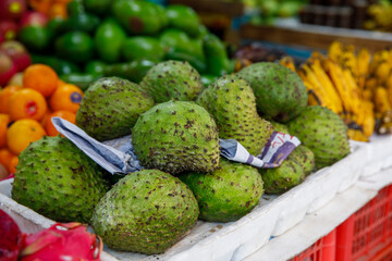 Soursop Guyabano Guanabana Graviola Exotic Green Fruit at Tropical Asian Market with Bananas and...
