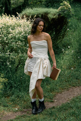 Young woman enjoys a sunny summer day in a stylish white dress among nature