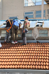 Ouvriers qui réparent des carreaux cassés sur une verrière