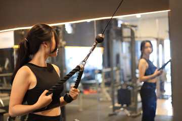 Young Woman Looking at the Mirror While Training at Gym