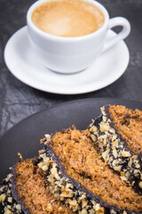 Zucchini dough on black plate and cup of white coffee. Delicious dessert