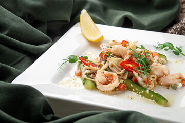 Gourmet shrimp salad with fresh cucumber, red pepper, sesame seeds, and microgreens, served with a...