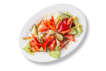 Colorful healthy vegetable salad with chopped tomatoes, cucumbers, bell peppers, red onions and lettuce leaves. Served with dressing on a white plate. Ideal for diet, vegan and clean food themes