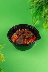 Overhead view of a traditional dish featuring stewed beef, chickpeas, and seasoned rice in a black...