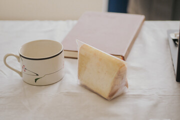 a cup of tea and a piece of sponge cake and a book