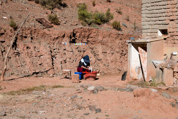 Woman washing clothes by hand outside her home. Handwash concept.