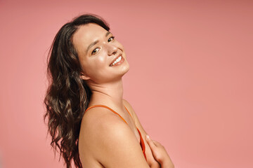 Obraz premium Stylish young woman showcases modern fashion against a vibrant pink backdrop in an artistic portrait