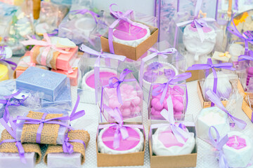 Lavender themed gift boxes with handmade soaps and candles tied in purple ribbons. Concept of lavender gifts as elegant packaging, fragrance decor, handmade craft. Light pastel background