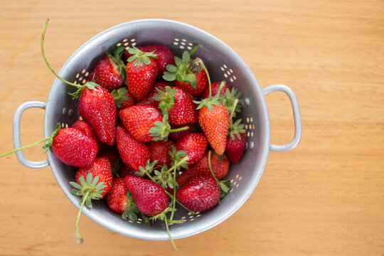 Fresh strawberries in steel colander