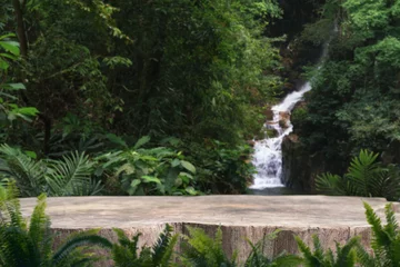 Fototapete Wasserfall wood stump table top podium with outdoor waterfall tropical forest nature background landscape.Natural water mineral product present placement pedestal wooden stand display.jungle paradise concept.  © 52Ps.Studio