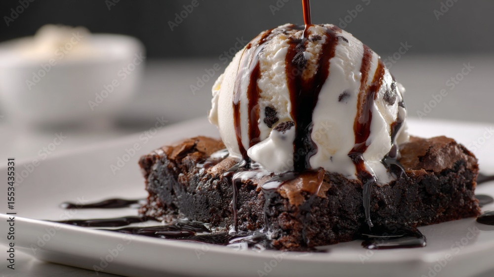 Poster A close-up of a chocolate brownie topped with a scoop of vanilla ice cream and drizzled with chocolate sauce, creating an indulgent dessert scene