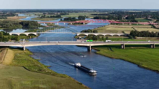 Zwolle, 12th of July 2025 Freighter on the IJssel River with the A28 near Zwolle with the IJssel Bridge, Katerveer II Bridge, and the Hanzeboog Bridge
