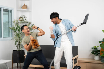 Playful cleaning moment. Two friends having fun while vacuuming and enjoying their time together.